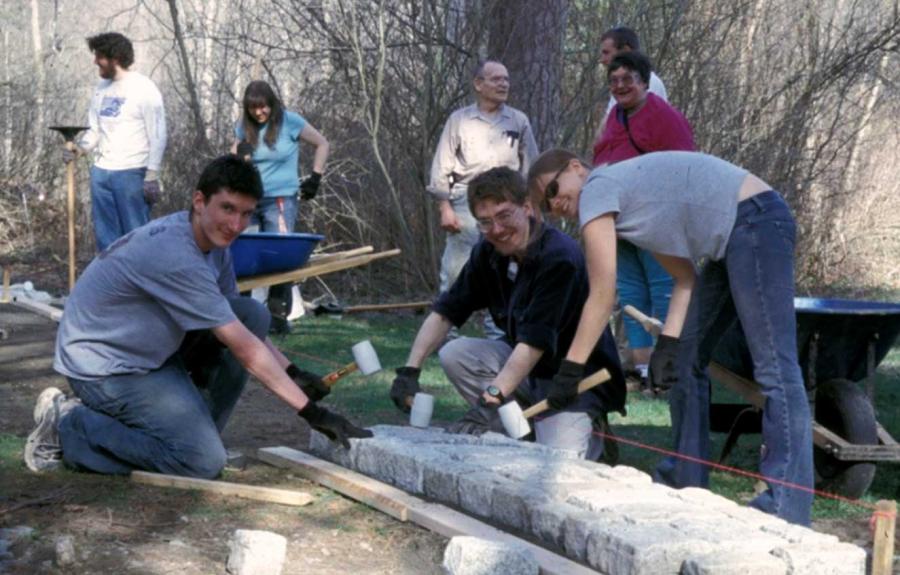 Students and members of the Friends installing the granite footprint at the site of the Budd House